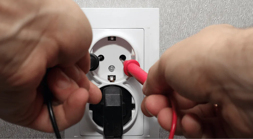 Elektricien die de bedrading van een stopcontact controleert